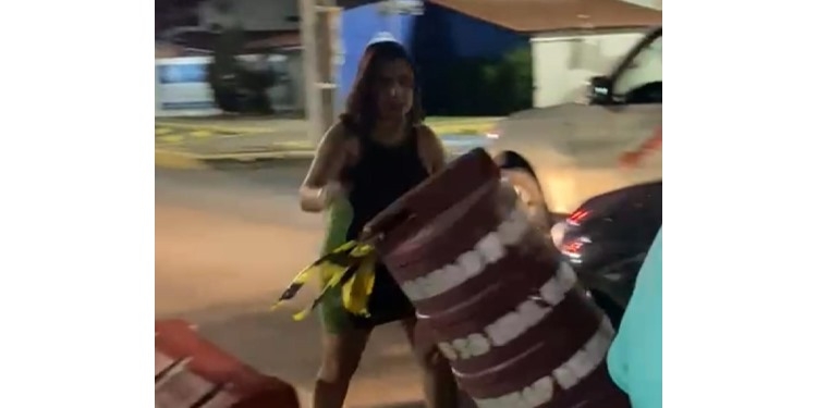 Mulher invade faixa e retira cones em área interditada para pedestres e ciclistas